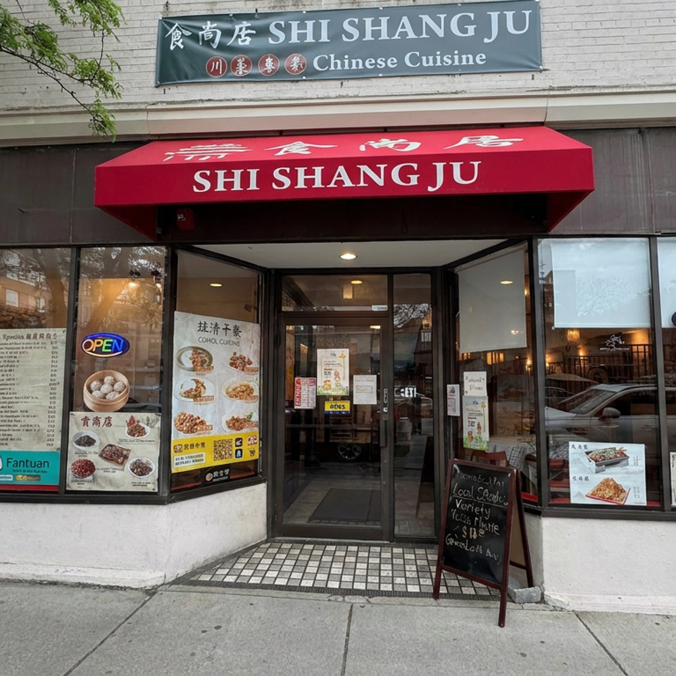 Street-facing Shi Shang Ju Chinese Cuisine restaurant entrance with red awning, illuminated open signs, food posters, and sidewalk chalkboard.